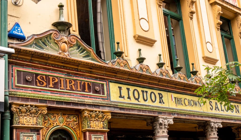 The Best Pub Guide - Step inside this charming pub and admire its eye-catching exterior, adorned with ornate tiles and classic signage boasting “SPIRIT LIQUOR THE CROWN SALOON” beneath striking yellow and green accents. A true gem for any lover of historic pubs, The Crown Saloon is an absolute must-visit when browsing the UK’s finest listings!. | Pub Directory UK